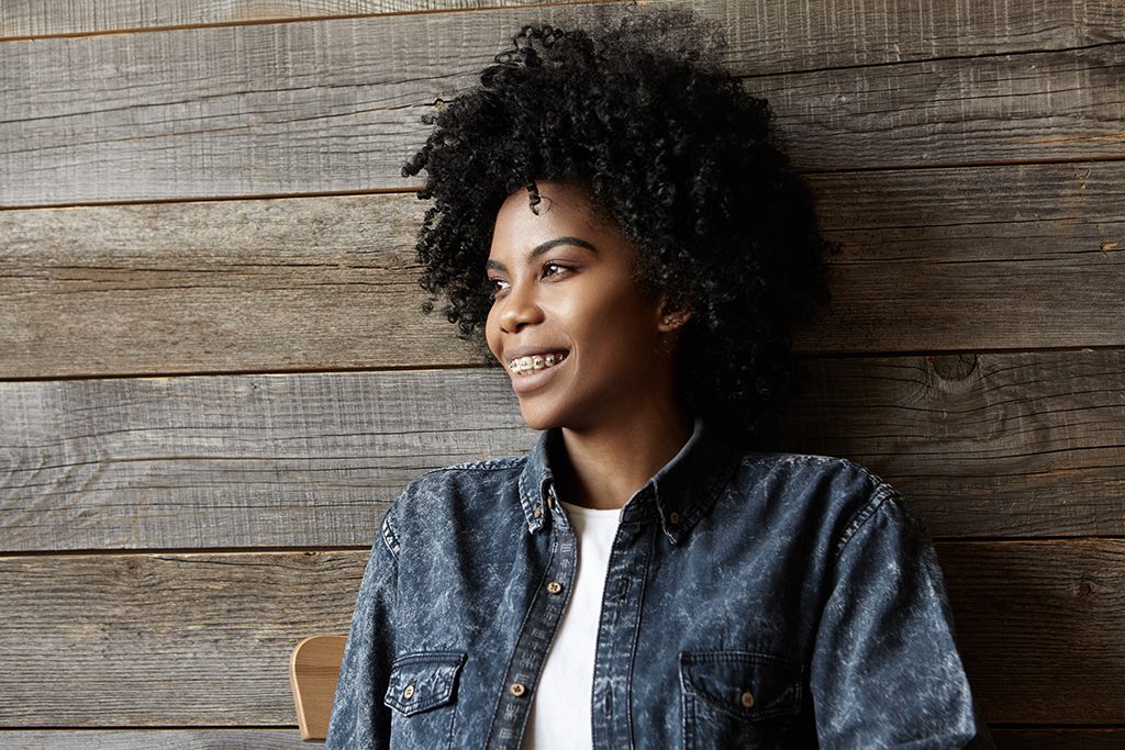 adult woman with braces against wood background